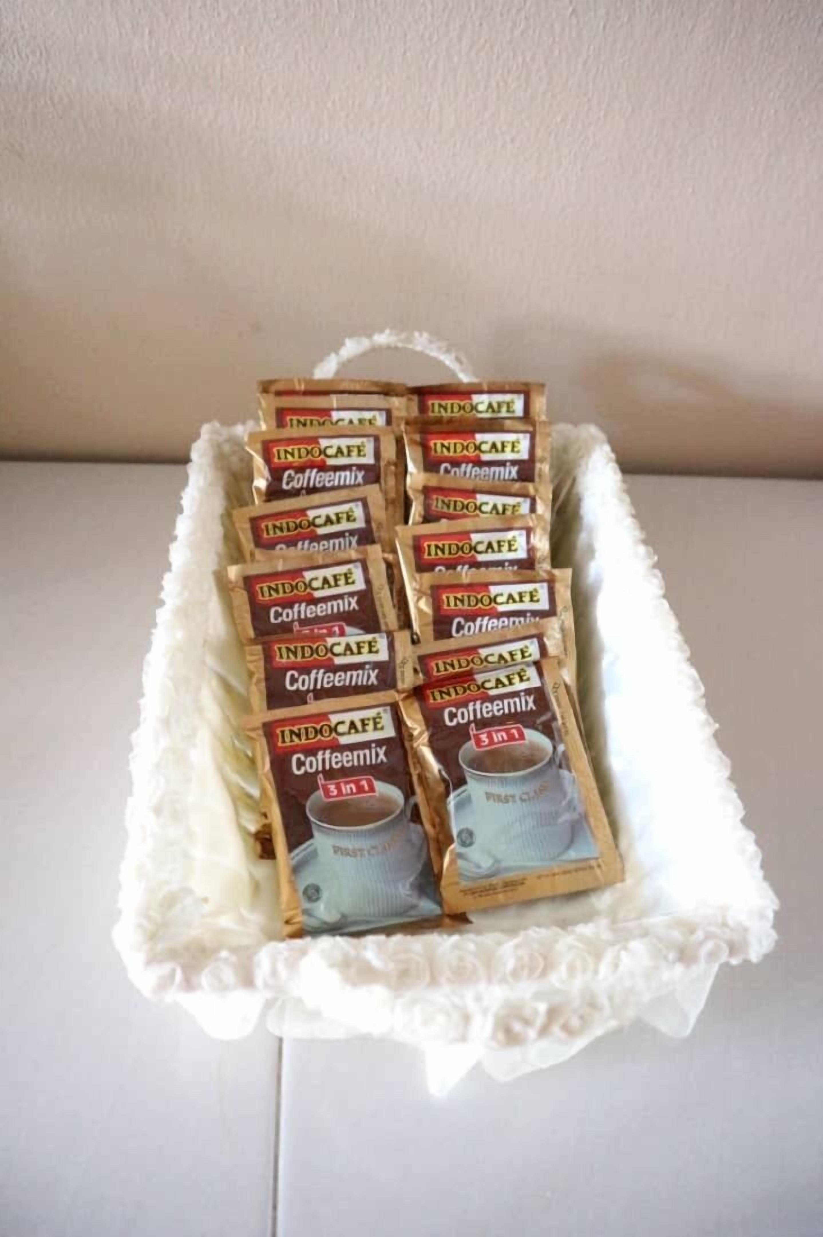 Una bandeja con sobres de café INDOCAFE Caffeemix dispuestos en un expositor decorativo.