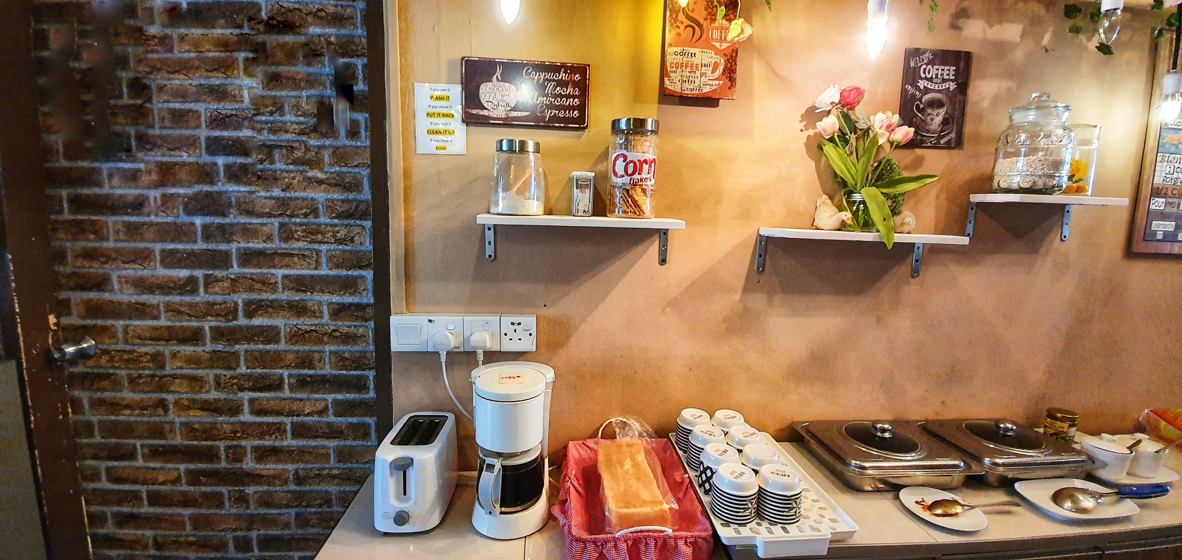 A coffee station with a coffee maker, a jar of corn flakes, and a toaster.
