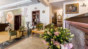 A lobby with a reception desk, seating area, and a staircase. - Hotel Caruso Old Town Prague (Prague)