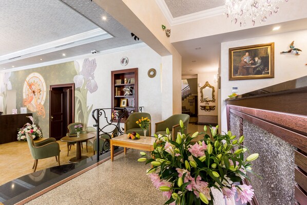 A lobby with a reception desk, seating area, and a staircase. - Hotel Caruso Old Town Prague (Prague)
