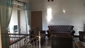 Un saló amb un sofà, butaques i una escala.