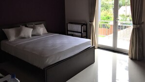 Habitació d'hotel amb un llit gran, una taula petita i vistes a l'exterior.