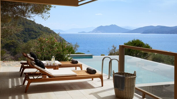 A terrace with wooden lounge chairs, a small pool, and a view of the sea and mountains. - ELIVI Skiathos (Skiathos)