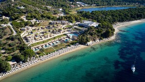 An aerial view of a coastal resort with a beach, pool area, and multiple buildings. - ELIVI Skiathos (Skiathos)