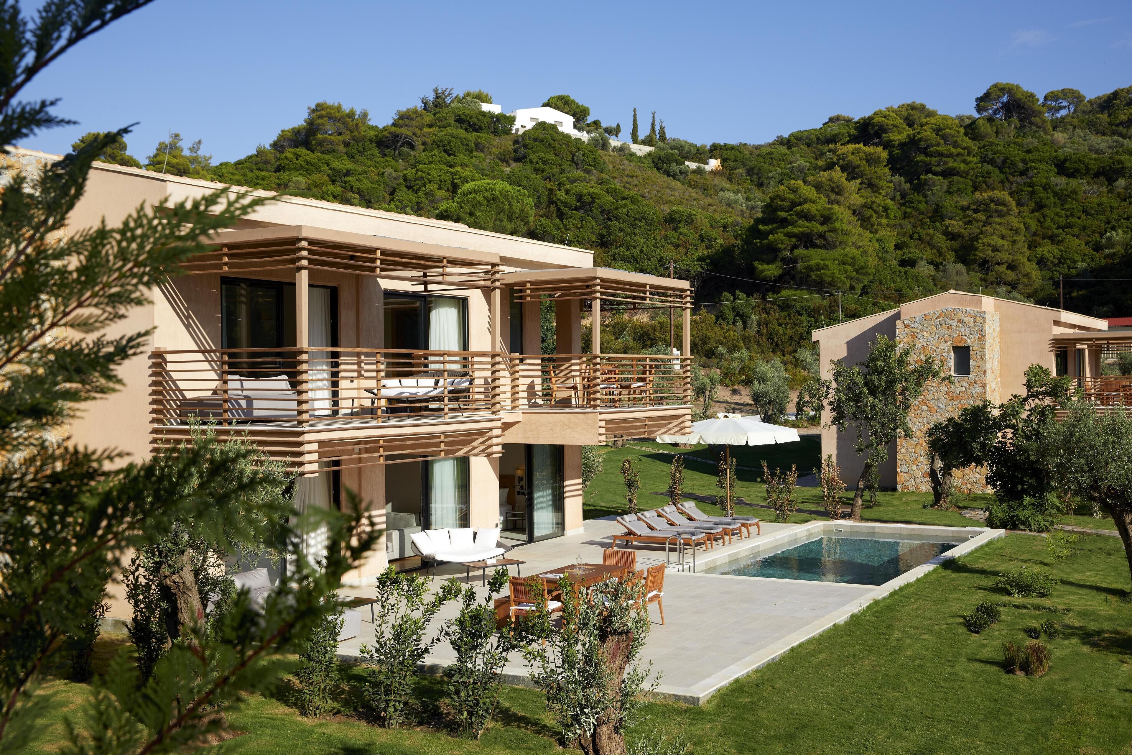 A modern villa with a pool, outdoor seating, and a lush garden.