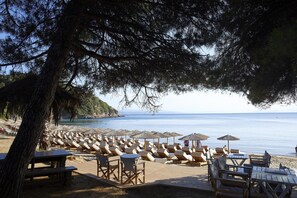 En la playa, camas de playa, sillas reclinables de playa, sombrillas