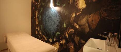 Une pièce comprenant un lit, un lavabo et une peinture murale.