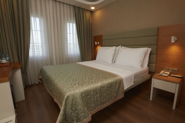 A hotel room with a bed, bedside table, and curtains. - Life Corner Hotel (Izmir)