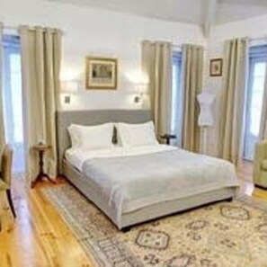 Ein Schlafzimmer mit einem großen Bett, einem Nachttisch und einer Wandlampe.