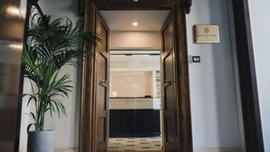 Ein Hotel Eingang mit Blumentopf, einer Rezeption und einem Schild an der Wand.