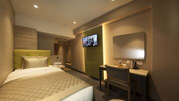A hotel room with a bed, a desk, a chair, a television, and a mirror.
