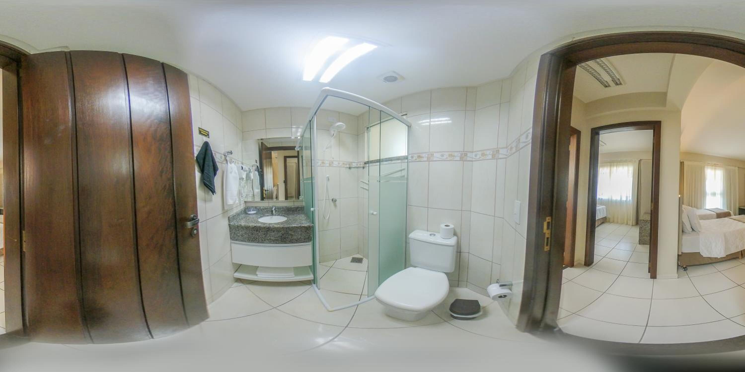Un baño con cabina de ducha de vidrio, inodoro y lavamanos.