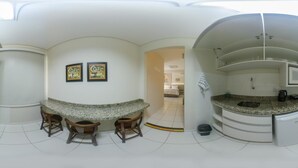 A modern kitchen with granite countertops, a built-in microwave, and a coffee station with two framed coffee mugs. - Pousada Doluar (Penha)