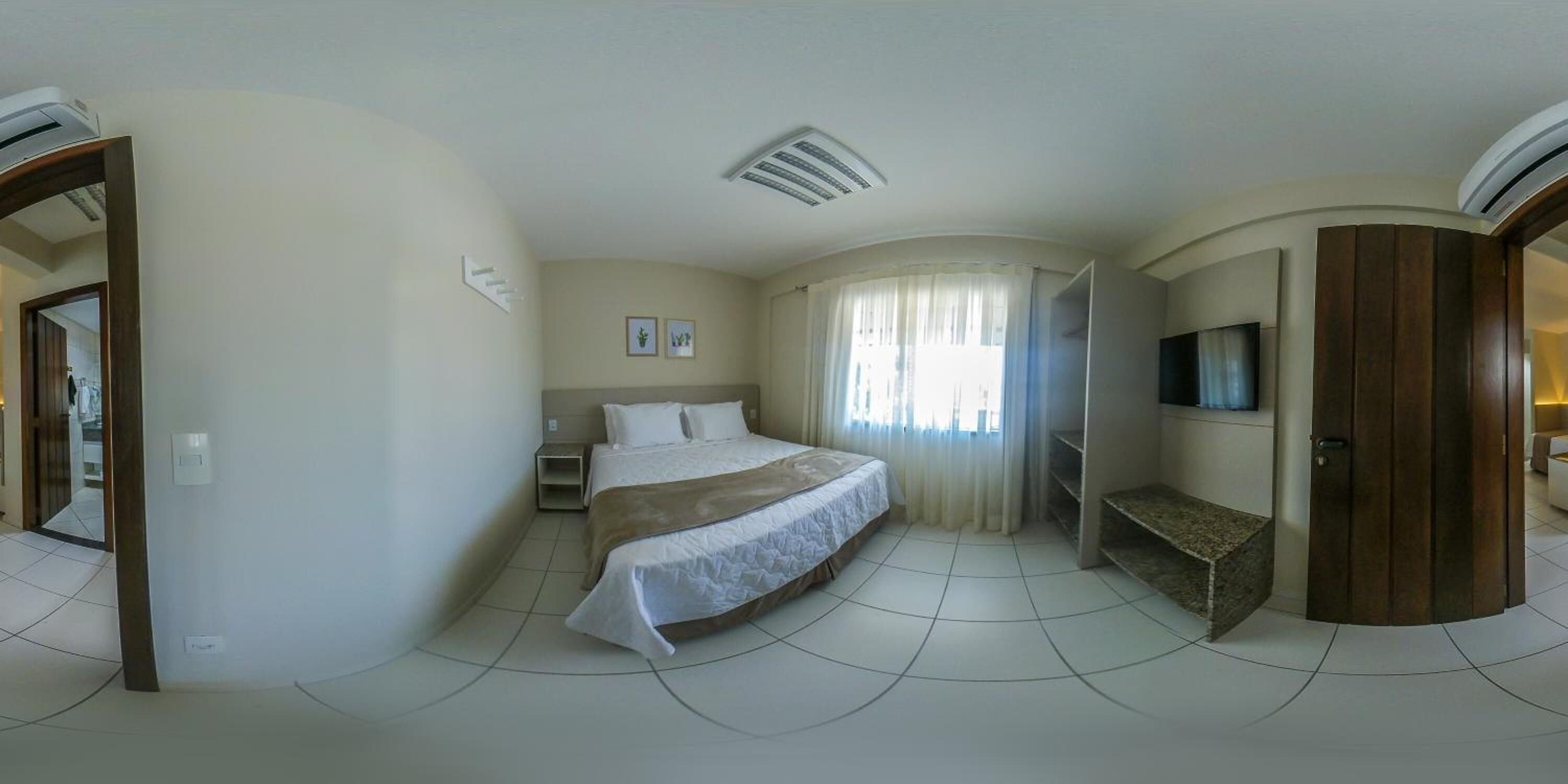 Une chambre à coucher avec un lit, une télévision, un bureau et une armoire.