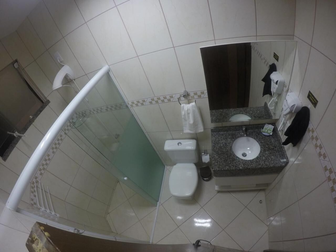 Une salle de bain avec une douche à parois de verre, des toilettes et un lavabo avec un miroir.