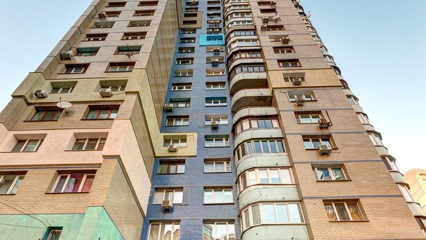 A multi-story residential building with a central entrance, balconies, and air conditioning units. - Dikat Hostel (Kyiv)