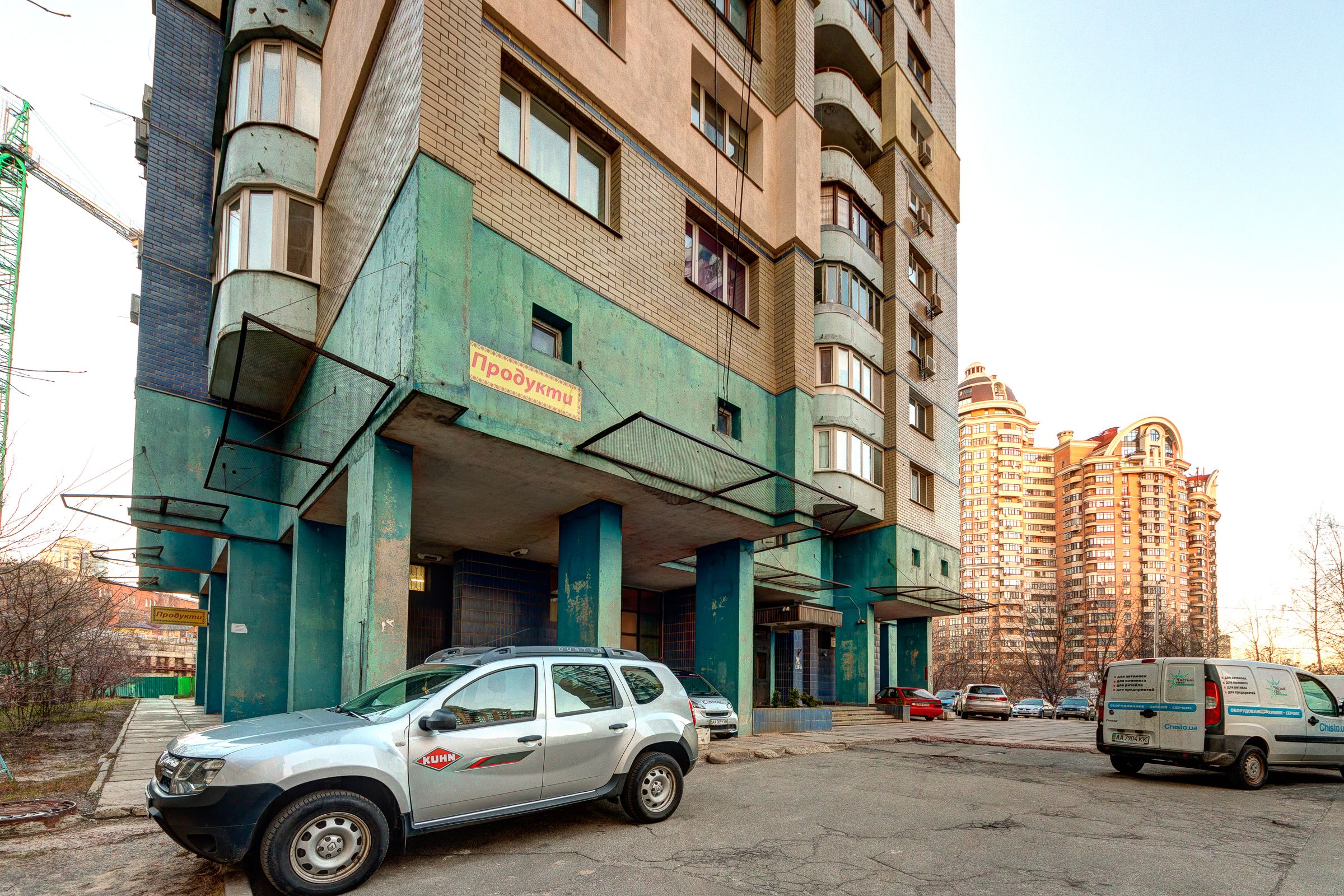 Um edifício de vários andares com fachada verde e uma placa com a inscrição 