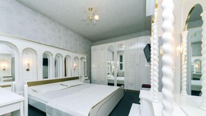 A bedroom with a large bed, a wardrobe, and a mirror. - Dikat Hostel (Kyiv)