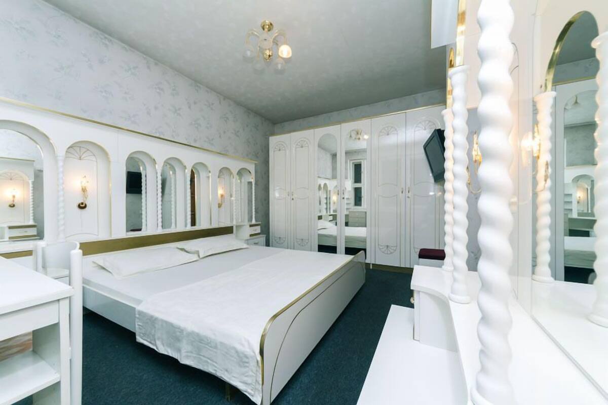 Un dormitorio con una cama grande, un armario y un espejo.