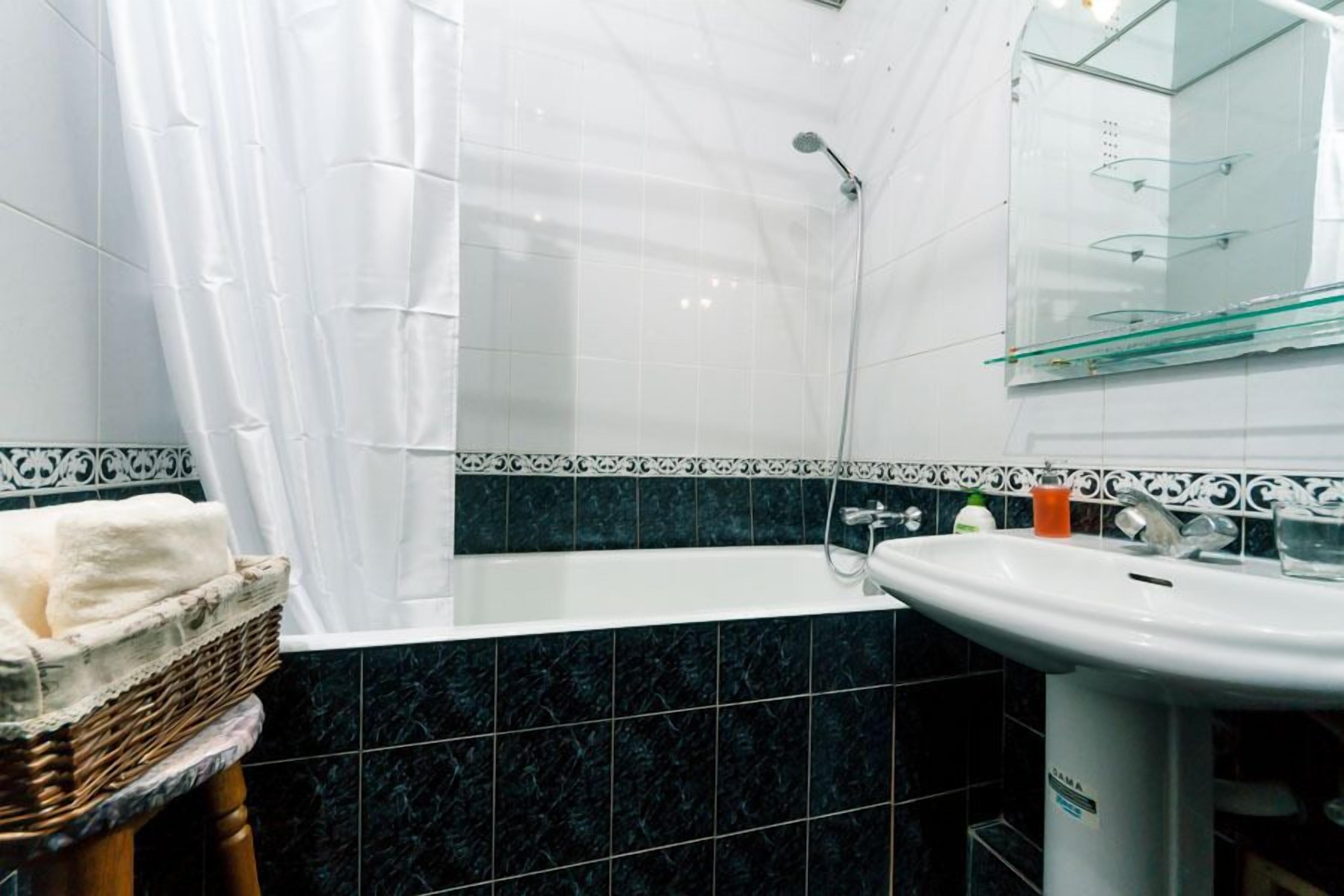 Un bany amb banyera, un lavabo i una dutxa.