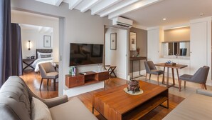 A modern living room with a flat-screen TV, comfortable seating, and a wooden coffee table. - Marine Beach Hotel Pattaya (Pattaya)