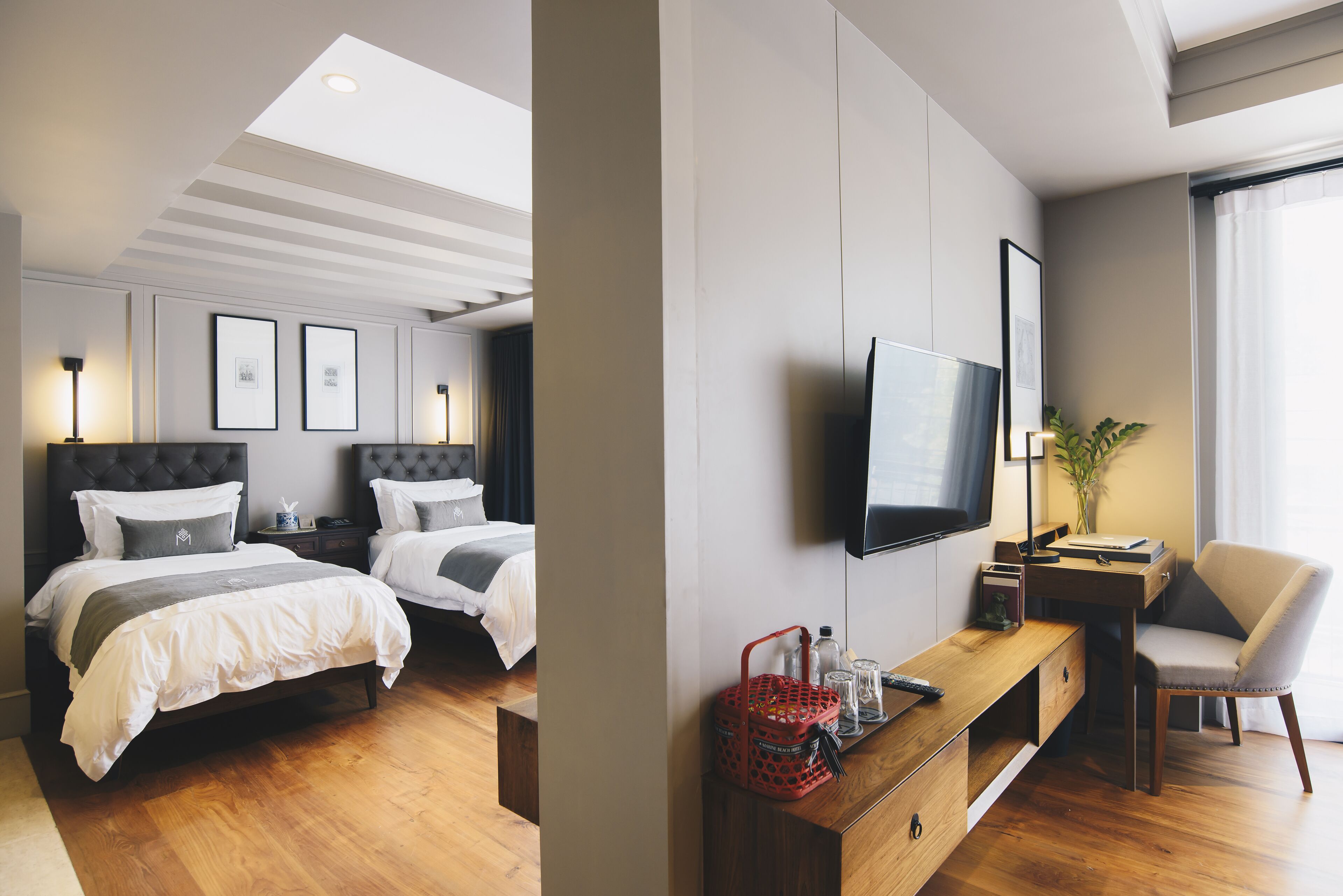 Een hotelkamer met twee bedden, een televisie, een bureau en een stoel.