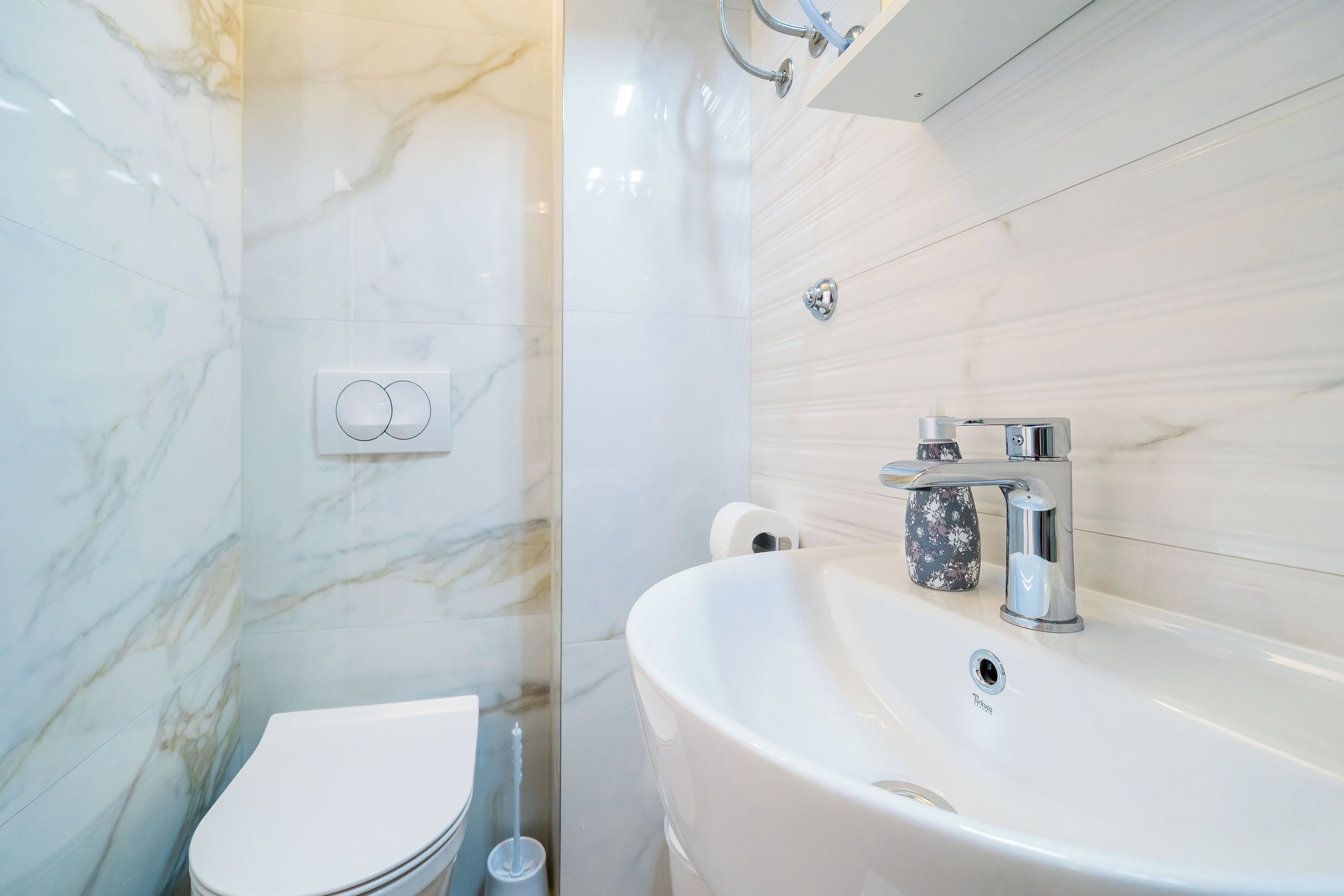 A bathroom with a white toilet, a sink, and a shower.