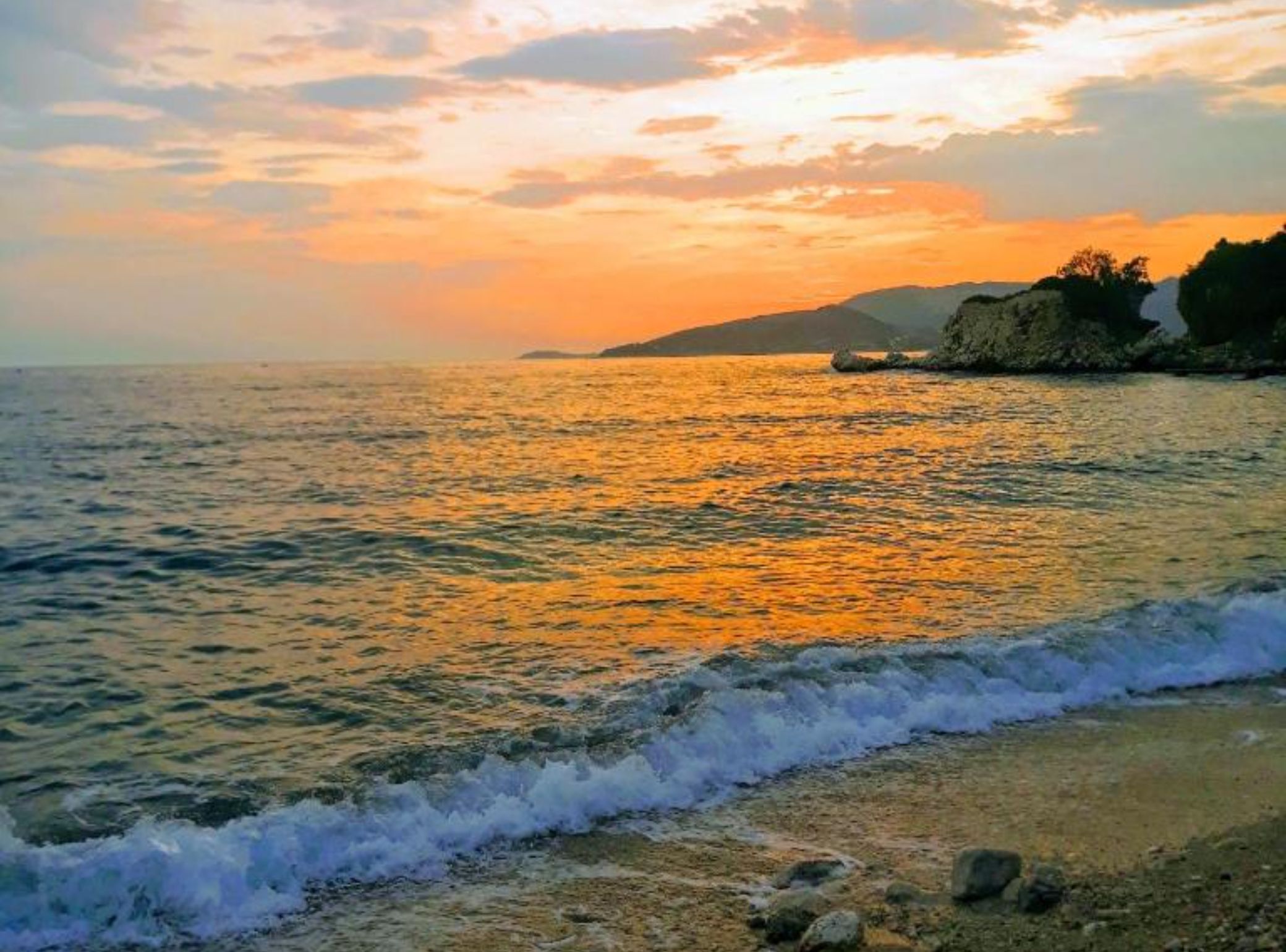 Una playa con olas al atardecer.