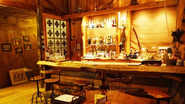 Een bar met houten wanden, een bar en een tafel met eten.