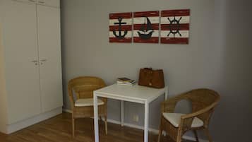 Escritorio, cortinas blackout y tabla de planchar con plancha
