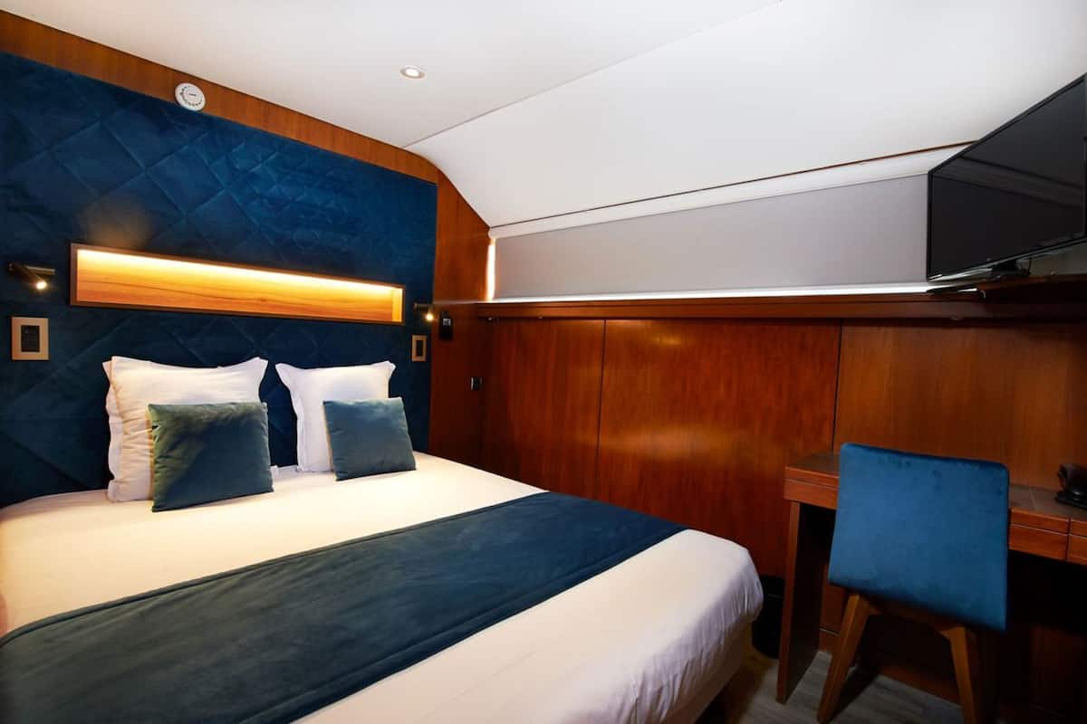 Ein Hotelzimmer mit einem großen Bett, einem Schreibtisch und einem Fernseher.
