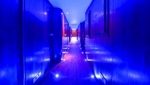 A long, narrow hallway with a wooden floor and walls painted in a deep blue color. - VIP Paris Yacht Hotel (Paris)