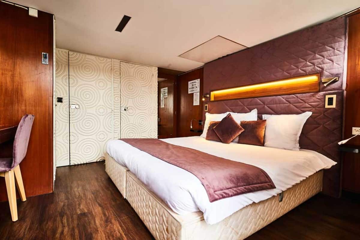 Ein Schlafzimmer mit einem großen Bett, einem Holzschrank und einem Schreibtisch mit Stuhl.