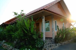 A house with a stone foundation, a tiled roof, and a porch with columns. - Ramiarndao Boutique Place Hotel (Amnatcharoen)