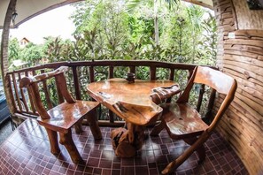 A wooden table and chairs on a balcony with a tiled floor, surrounded by a wooden railing. - Ramiarndao Boutique Place Hotel (Amnatcharoen)
