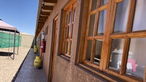 Ein Gebäude mit einem pflasterbelagten Weg, Holzfenstern und gelben Gasflaschen.