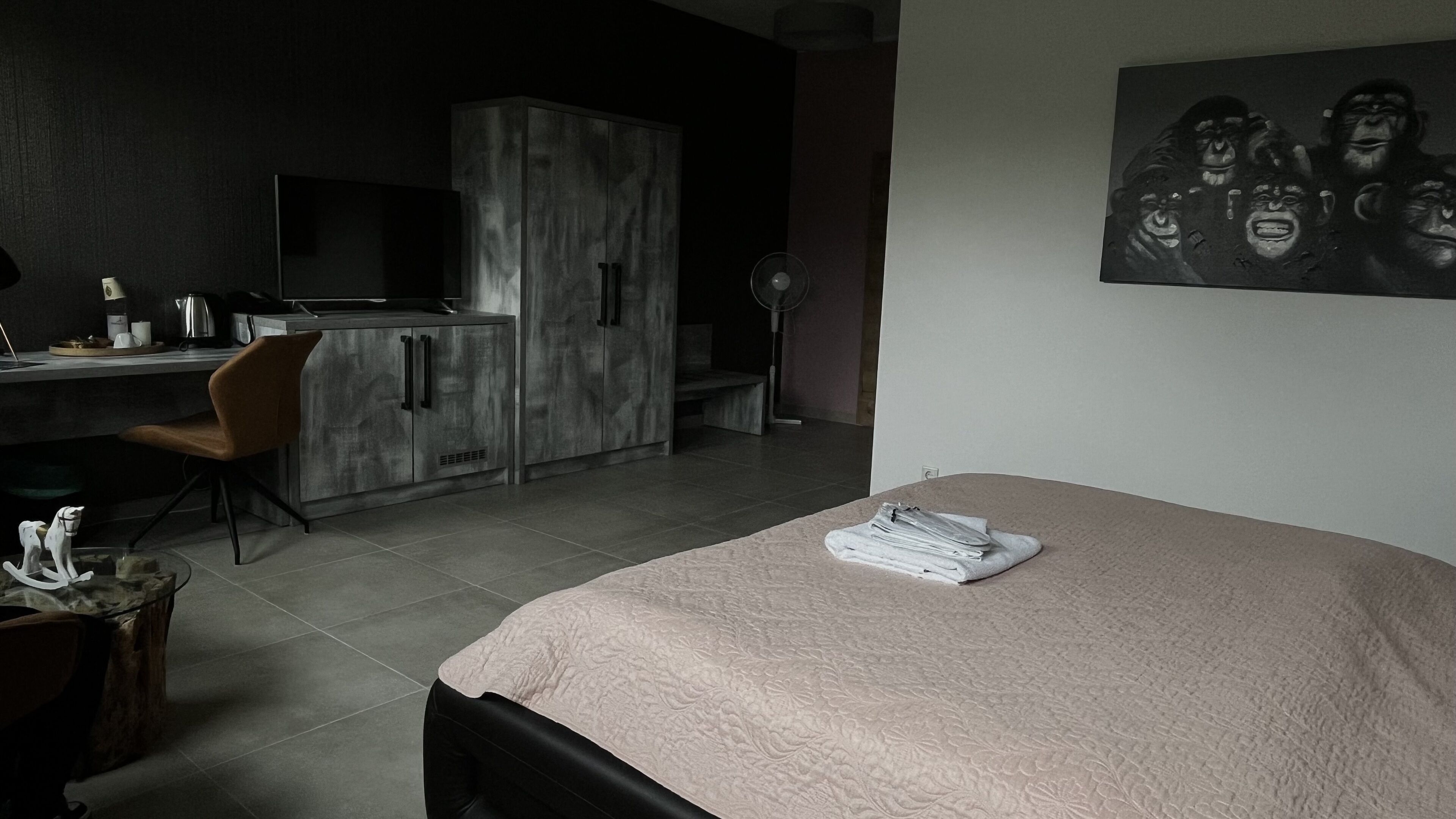Ein modernes Schlafzimmer mit Bett, Schreibtisch und Kleiderschrank.