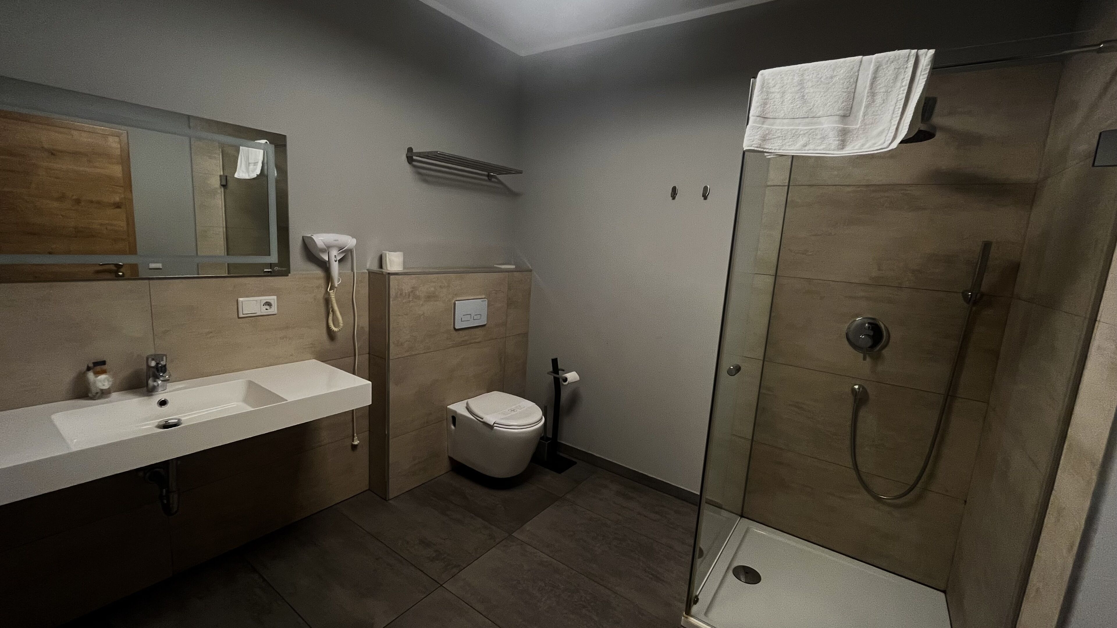 Ein modernes Badezimmer mit Dusche, Toilette und Waschbecken.