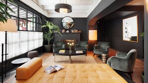 A modern living room with a sofa, two armchairs, a coffee table, and a fireplace. - LA FRANÇA HOTEL BOUTIQUE (Barcelona)