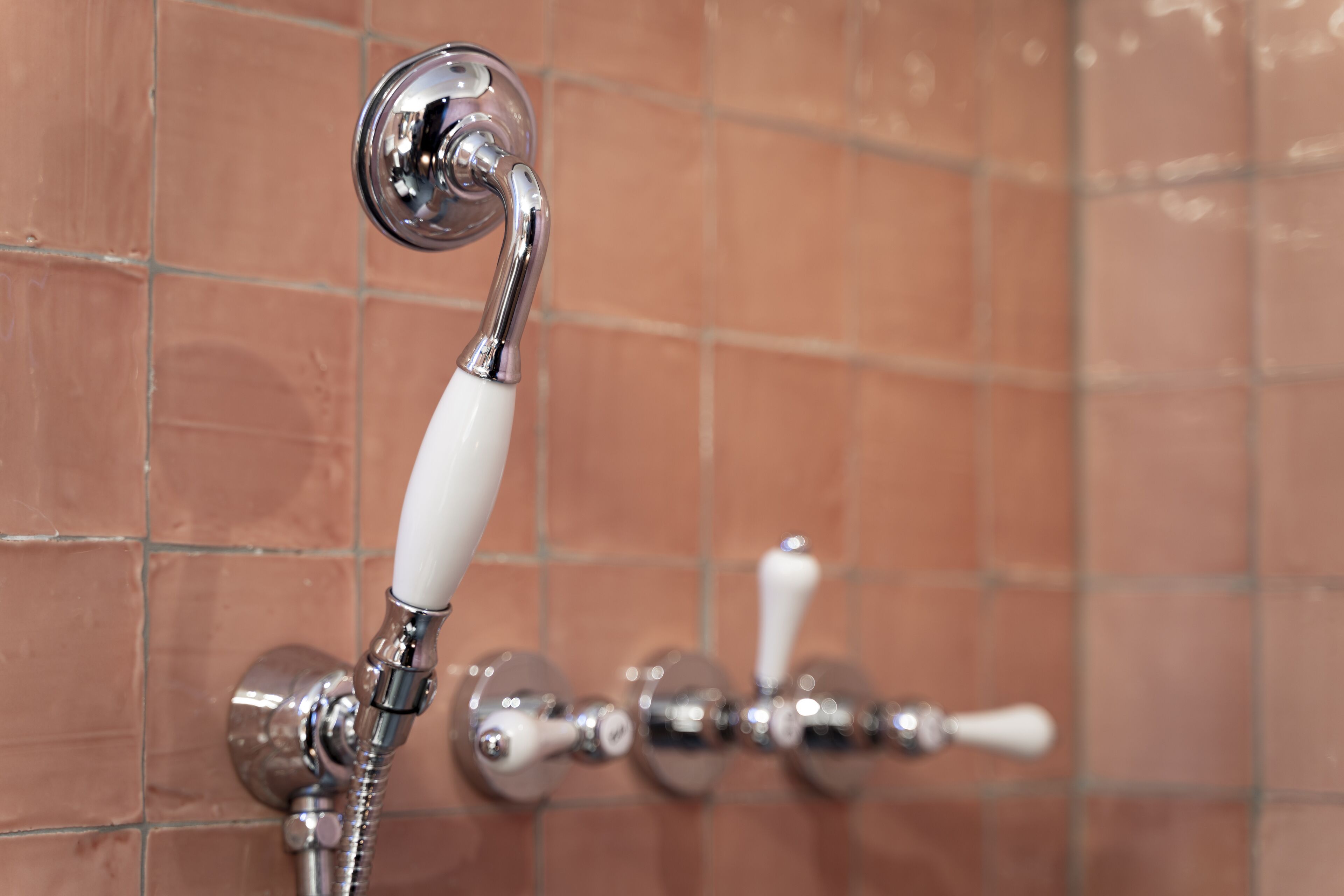Un baño con cabezal de ducha y control de ducha manual.