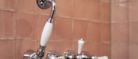 Un baño con cabezal de ducha y control de ducha manual.