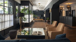 A modern lobby with a sofa, chairs, a coffee table, and large windows. - LA FRANÇA HOTEL BOUTIQUE (Barcelona)