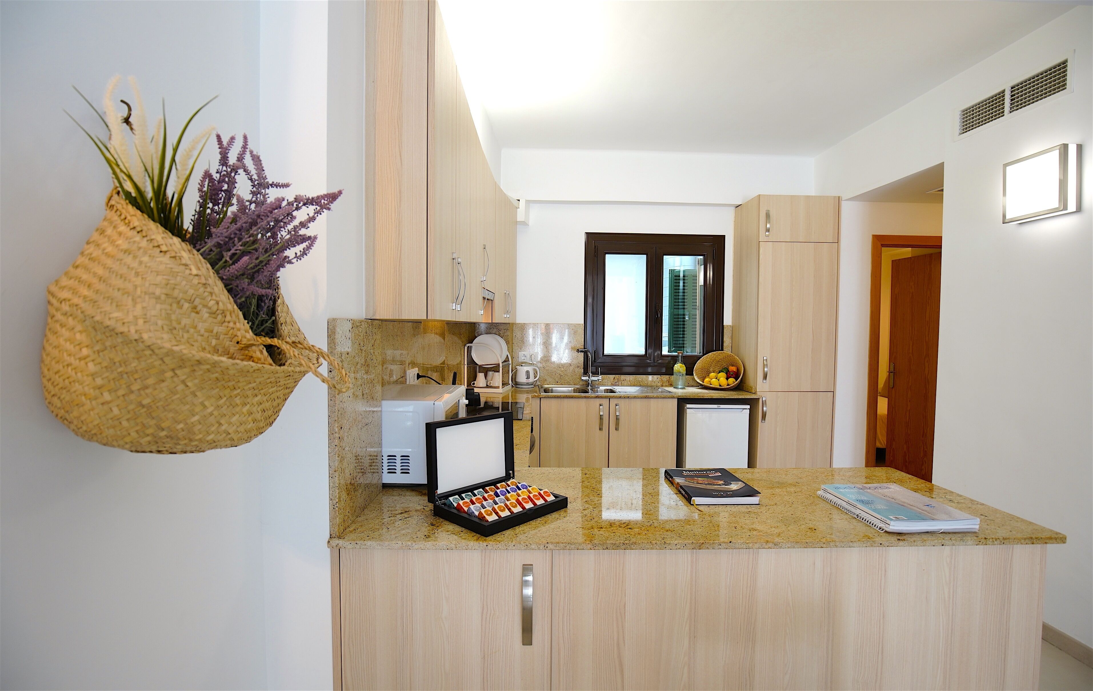 A modern kitchen with wooden cabinets, a built-in microwave, and a small island with a coffee machine.