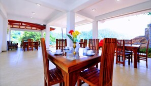 Comedor con muebles de madera y un jarrón de flores sobre la mesa.