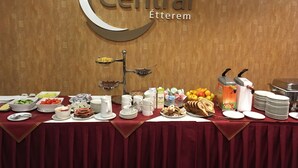 A buffet setup with various food items and beverages, a sign reading "Hotel Central Etterem", and a wooden wall in the background. - Hotel Centrál (Nagykanizsa)