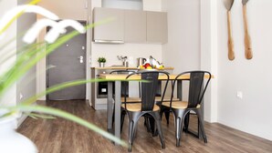 A modern kitchen with a wooden table and four chairs, a sink, and a stove. - Athens Connection Apartments (Athens)