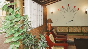 A cozy seating area with a brick wall, a decorative crown wall art, and a potted plant.