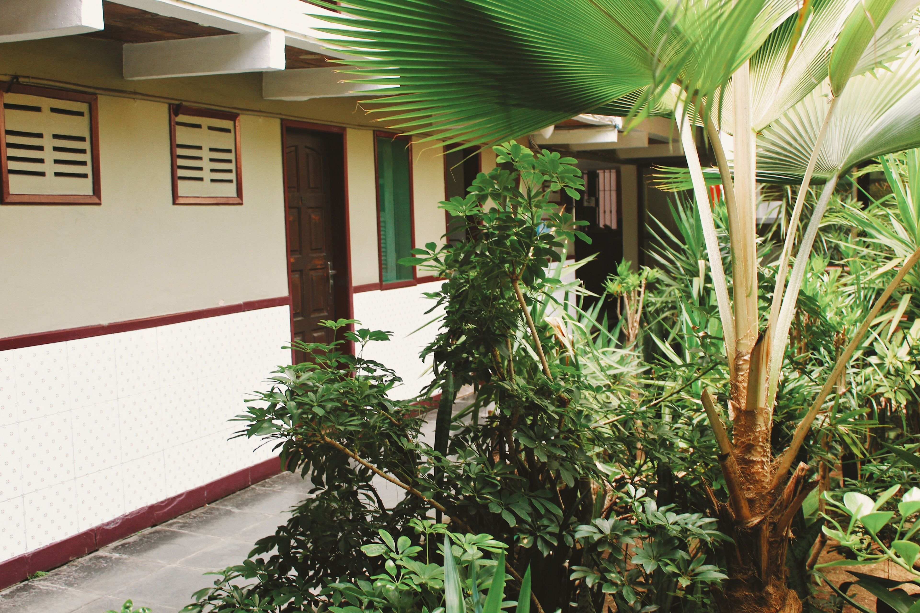 A building with a tiled exterior, a red trim, and a door.