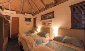 A room with two beds, wooden beams on the ceiling, and framed pictures on the wall. - Marina 6 (Punta Cana)