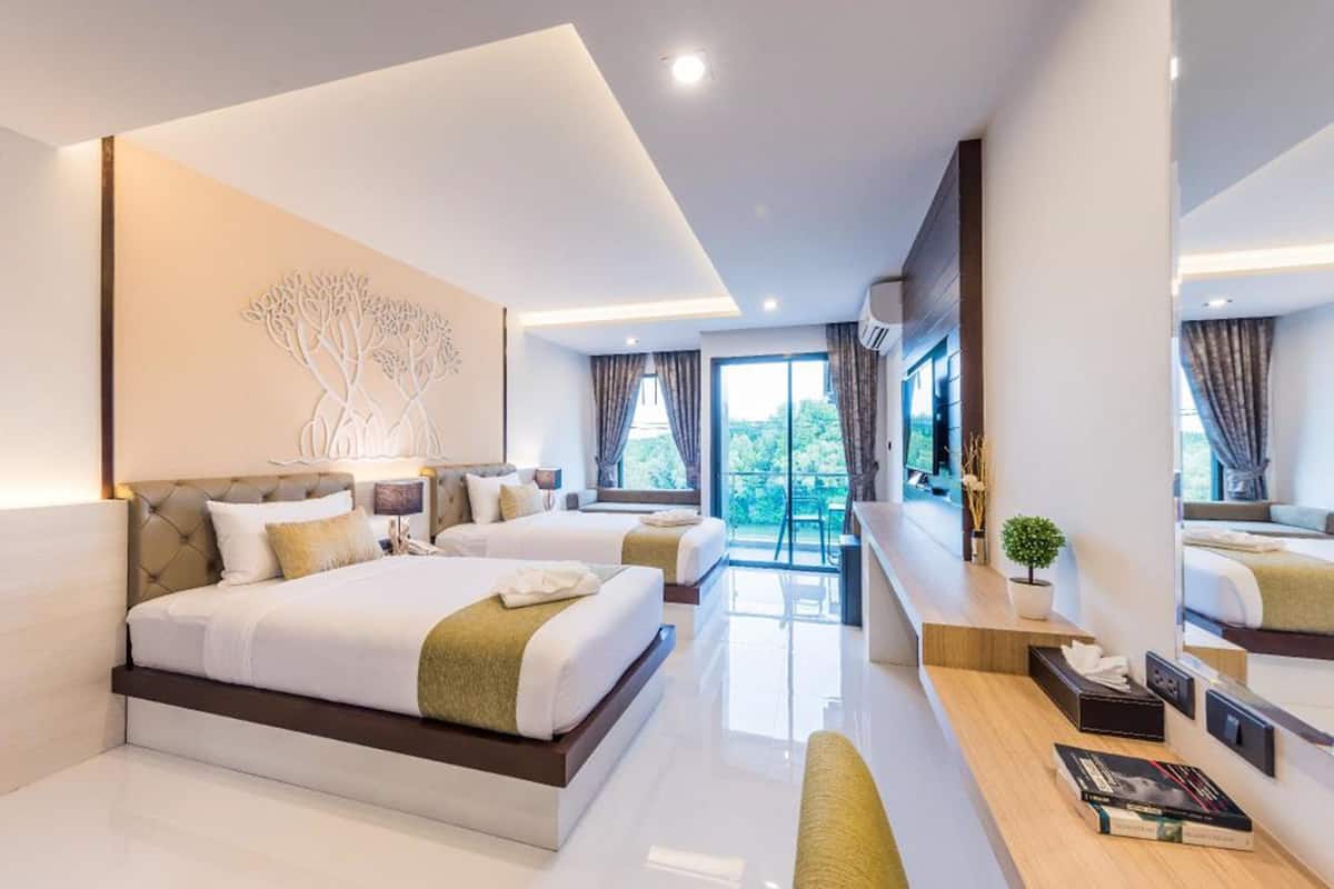 Habitación de hotel moderna con una cama grande, un escritorio y vistas al exterior.